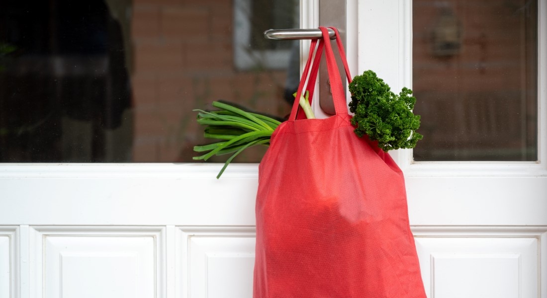 Groceries on door handle symbolising nabour help. Photo: Colourbox